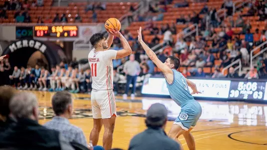 Luis Hurtado Jr. shooting a three-pointer with a defender guarding him