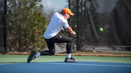 Marceau Foulihoux kneeling to hit a backhand shot