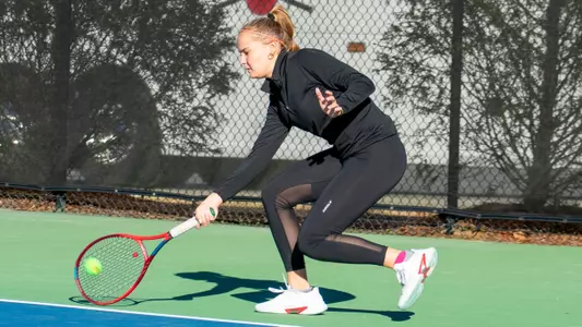 Eden Schlagenhauf reaching down to hit a shot near the court surface with her right hand