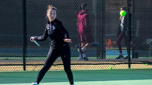 Teodora Ristic swinging to hit a forehand shot with her right hand