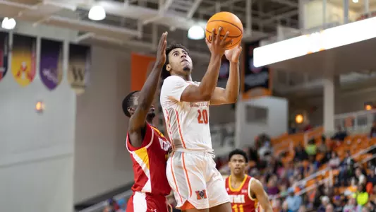 Braden Sparks jumping towards the basket for a lay in while a defender tries to guard him