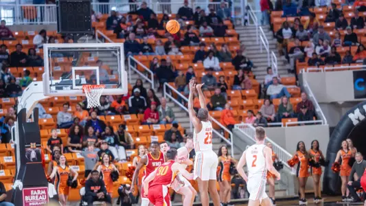 A wide angle shot from behind of James Glisson III shooting the basketball