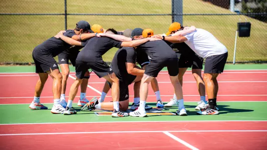 Men's tennis team in a huddle