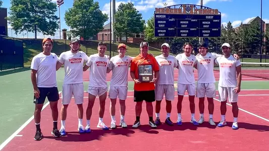 Andrew Branicki holding his senior day plaque standing with his teammates