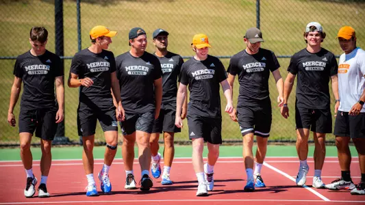 Men's tennis team walking across the court