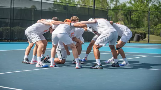 Men's tennis team in a huddle