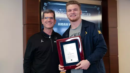 Jim Harbaugh (left), Aidan Hutchinson (Michigan Athletics)