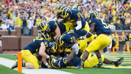 Michigan's defense celebrates Willie Henry's interception return for a TD