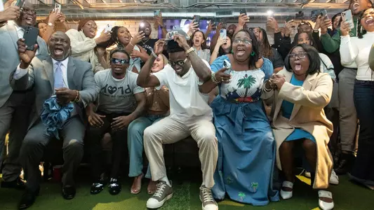 Family and friends celebrate Mike Sainristil being drafted by Washington Commanders in the second round during his NFL Draft watch party in Ann Arbor