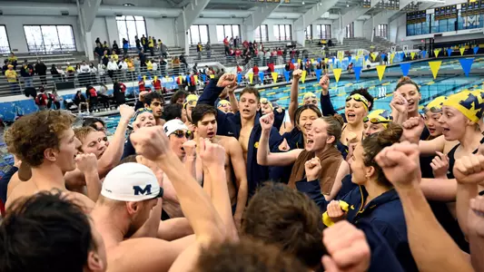 Men's and women's swimming team huddle