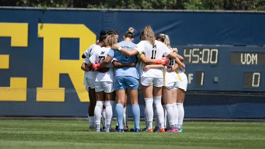 Women's soccer team huddle at home