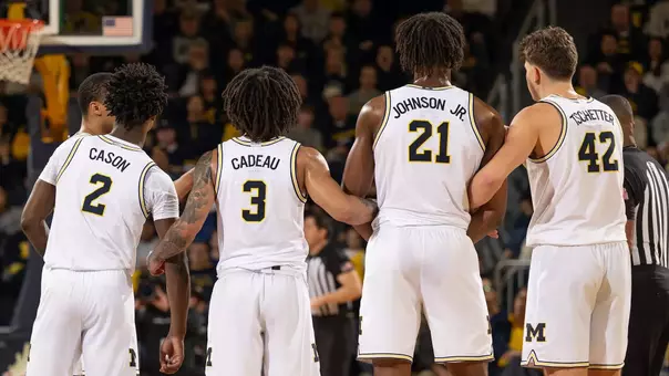 Men's basketball team huddle on the court