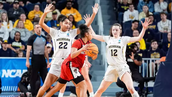 Kendall Dudley (22) and guard Syla Swords (12) defend NC State guard Zamareya Jones (3) during the first half of NCAA Tournament Second Round at Crisler Center in Ann Arbor on Sunday, March 22, 2026. (Imagn Images)