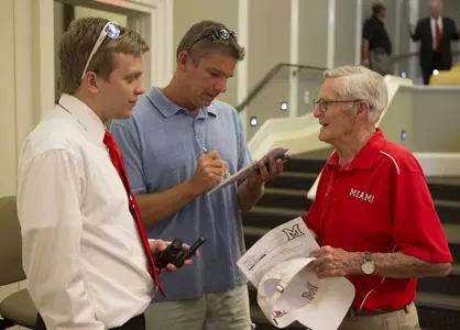 Wayne Gibson '48 talks with reporters about the new uniform