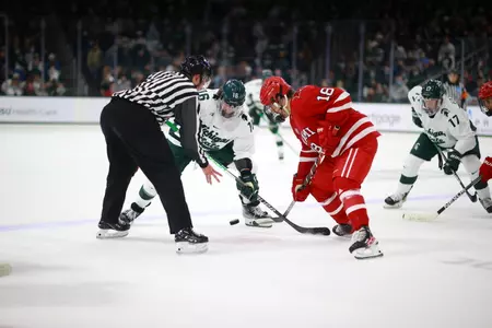 Monte Graham (18) takes a faceoff against Michigan State