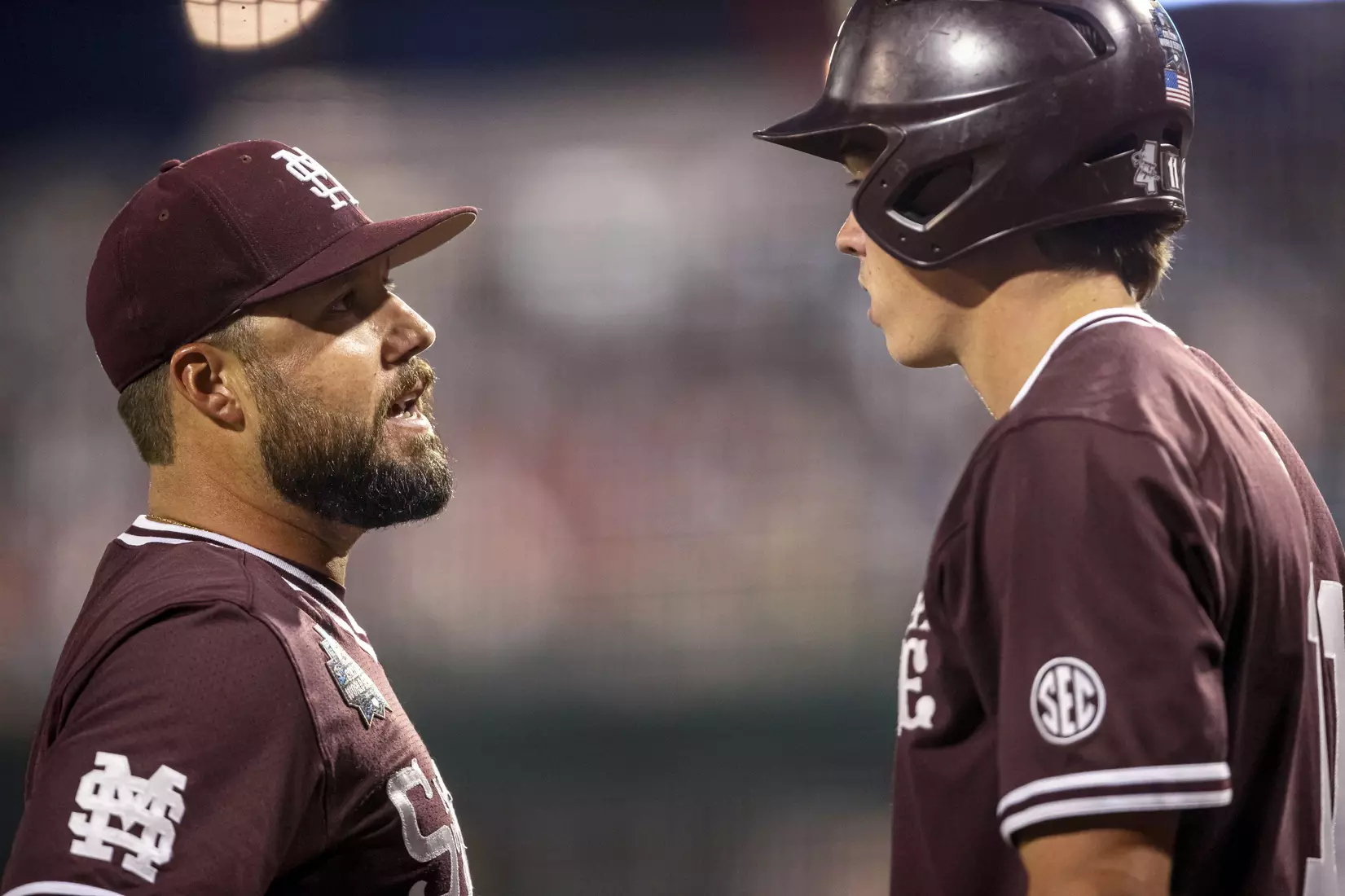 OMAHA, NE - June 22, 2021 - Mississippi State Assistant Coach Jake Gautreau speaks with Outfielder Kellum Clark (#11) during the 2021 Mens College World Series game between the Mississippi State Bulldogs and the Virginia Cavaliers at TD Ameritrade Park in Omaha, NE. Photo By Austin Perryman