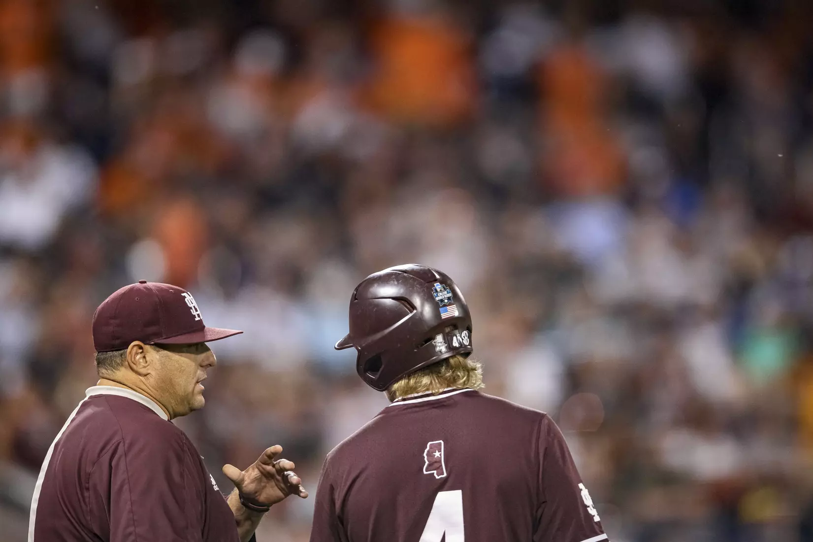 OMAHA, NE - June 22, 2021 - Mississippi State Head Coach Chris Lemonis speaks to Outfielder Rowdey Jordan (#4) during the 2021 Mens College World Series game between the Mississippi State Bulldogs and the Virginia Cavaliers at TD Ameritrade Park in Omaha, NE. Photo By Austin Perryman