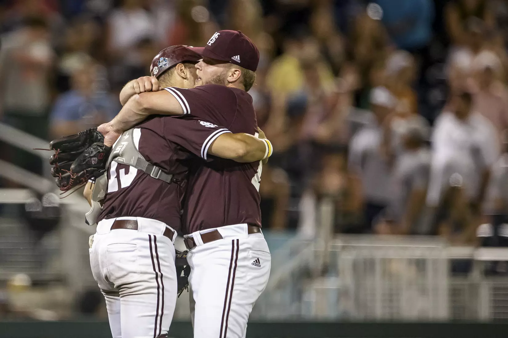 OMAHA, NE - June 22, 2021 - Mississippi State Catcher Logan Tanner (#19) and Pitcher Landon Sims (#23) hug after the 2021 Mens College World Series game between the Mississippi State Bulldogs and the Virginia Cavaliers at TD Ameritrade Park in Omaha, NE. Photo By Austin Perryman