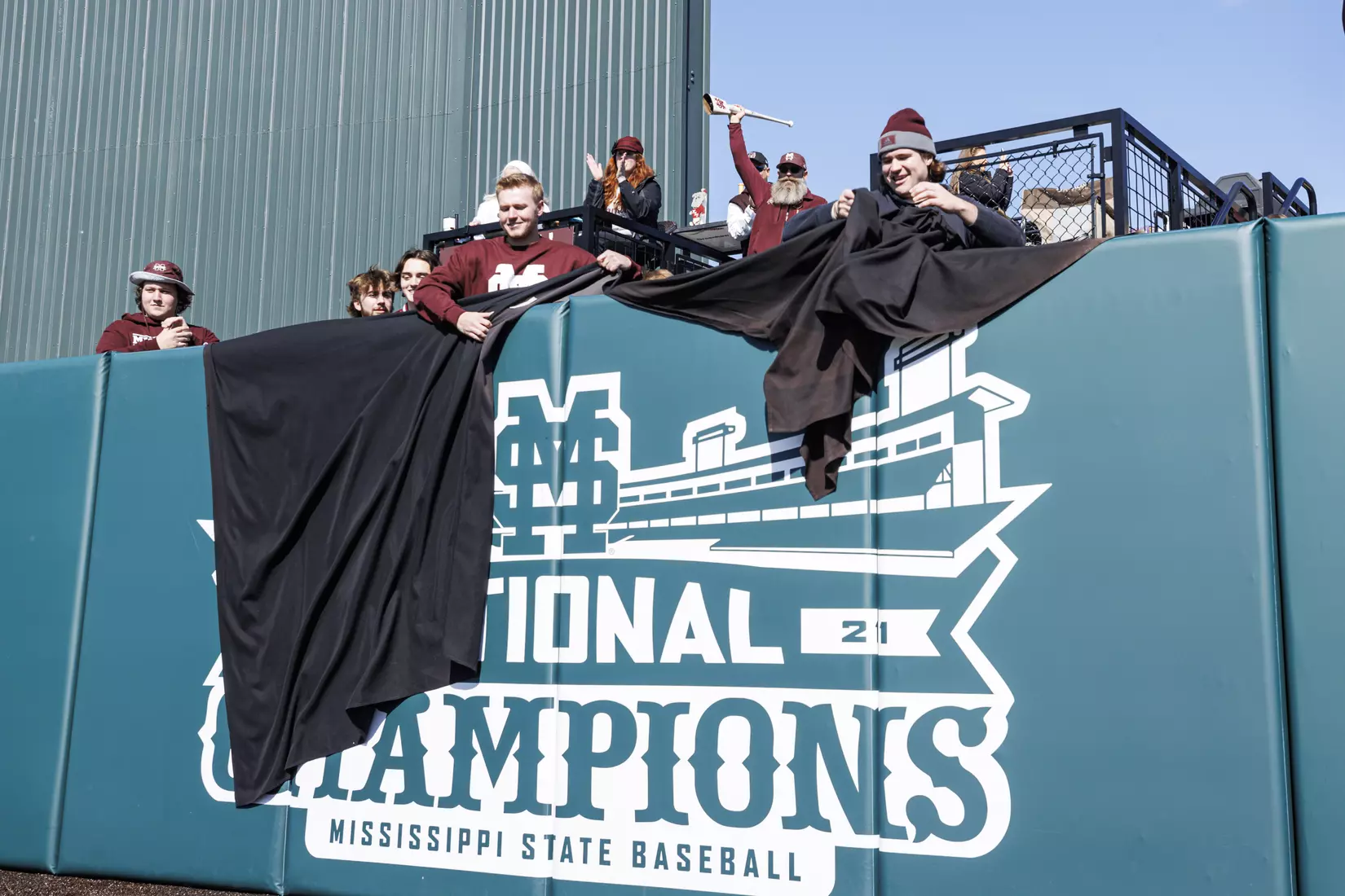 STARKVILLE, MS - February 18, 2022 - Former Mississippi State Pitchers Houston Harding (#48) and Christian MacLeod (#28) unveil the National Championship signage on the centerfield fence before the game between the Long Beach State Dirtbags and the Mississippi State Bulldogs at Dudy Noble Field at Polk-Dement Stadium in Starkville, MS. Photo By Kevin Snyder
