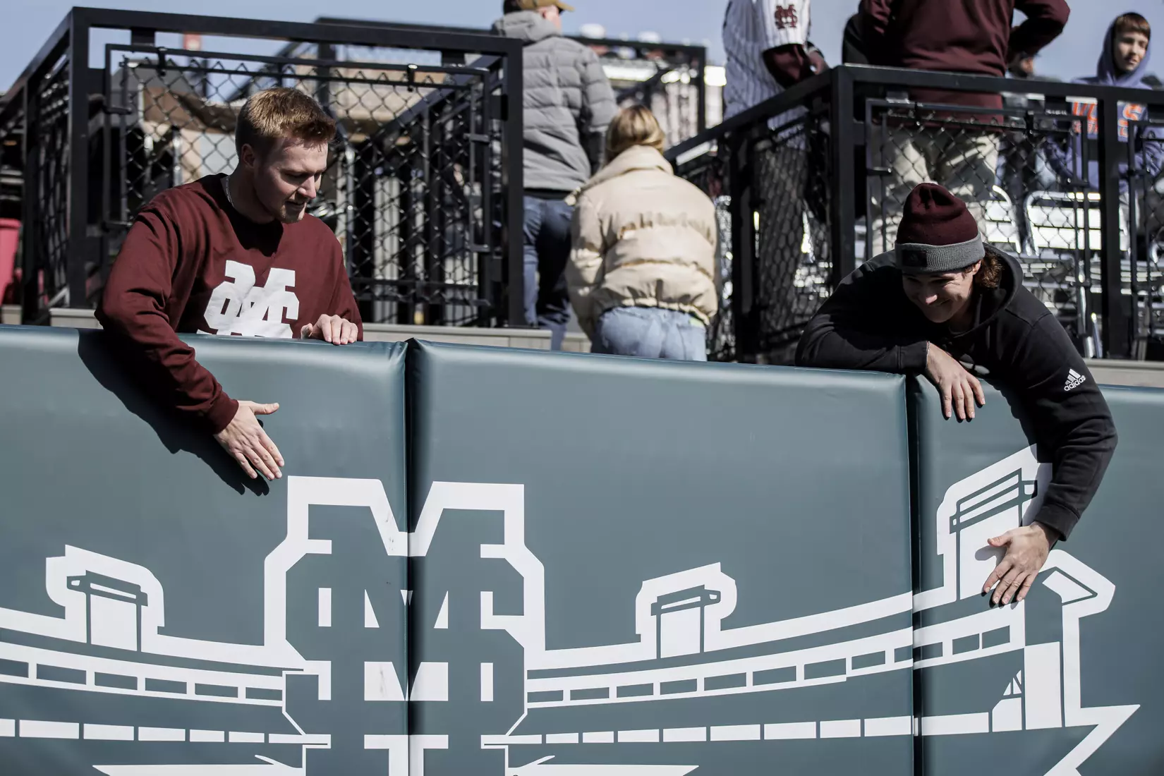 STARKVILLE, MS - February 18, 2022 - Former Mississippi State Baseball Players Christian MacLeod and Houston Harding unveil a new outfield wall graphic commemorating the 2021 Baseball National Championship before the game between the Long Beach State Dirtbags and the Mississippi State Bulldogs at Dudy Noble Field at Polk-Dement Stadium in Starkville, MS. Photo By Austin Perryman