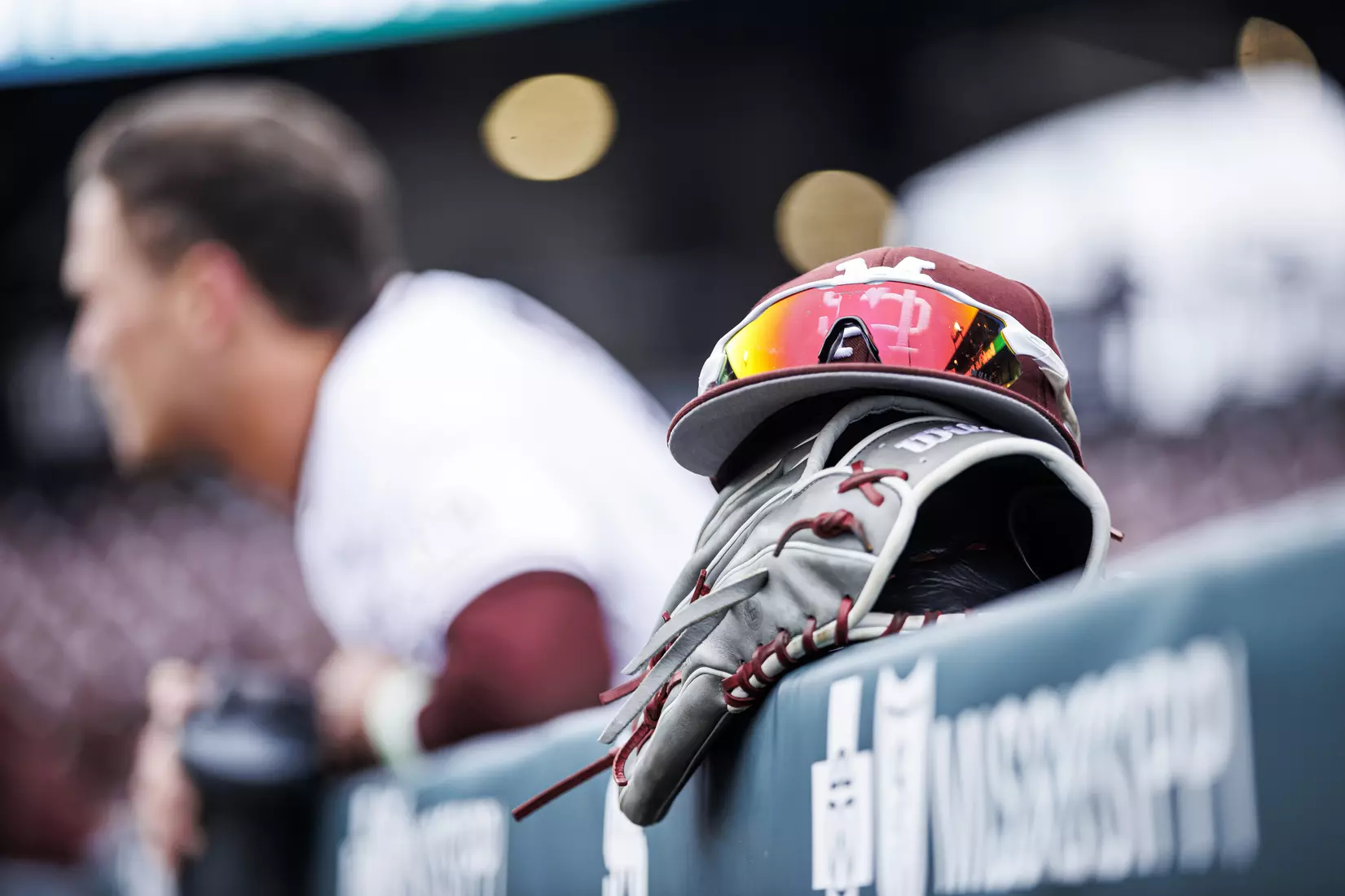 STARKVILLE, MS - February 26, 2022 - Mississippi State hat and sunglasses perched on a glove on the dugout railing before the game between the Northern Kentucky Norse and the Mississippi State Bulldogs at Dudy Noble Field at Polk-Dement Stadium in Starkville, MS. Photo By Kevin Snyder
