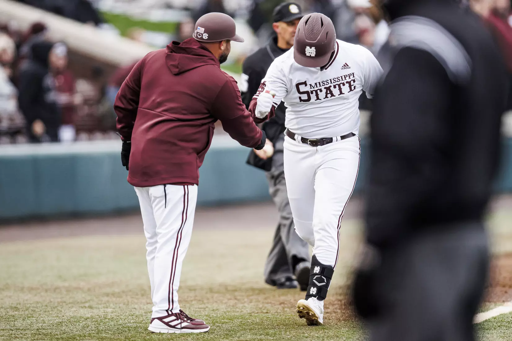 STARKVILLE, MS - February 26, 2022 - Mississippi State Catcher Logan Tanner (#19) fist bumps Assistant Coach Jake Gautreau after a home run during the game between the Northern Kentucky Norse and the Mississippi State Bulldogs at Dudy Noble Field at Polk-Dement Stadium in Starkville, MS. Photo By Kevin Snyder
