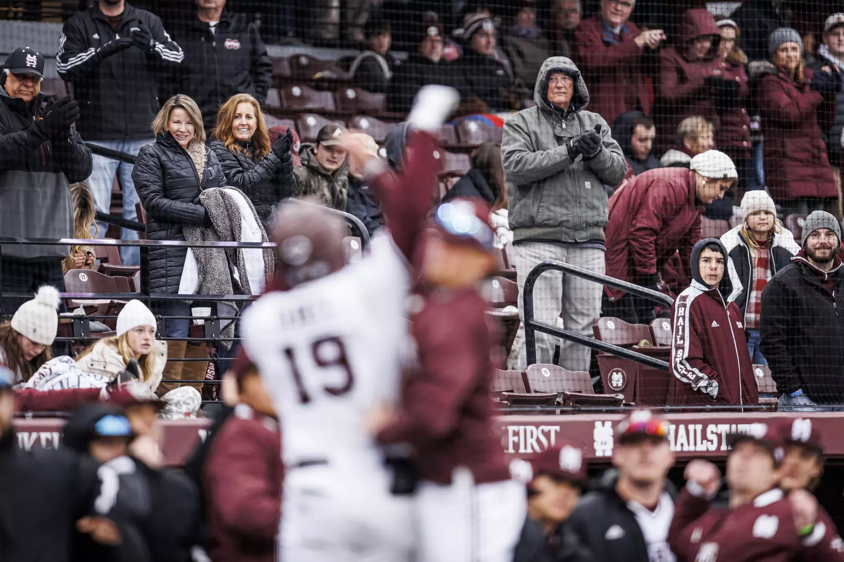 STARKVILLE, MS - February 26, 2022 - Fans watch as Mississippi State Catcher Logan Tanner (#19) and Mississippi State Infielder/Outfielder Matt Corder (#14) celebrate TannerÕs home run during the game between the Northern Kentucky Norse and the Mississippi State Bulldogs at Dudy Noble Field at Polk-Dement Stadium in Starkville, MS. Photo By Kevin Snyder