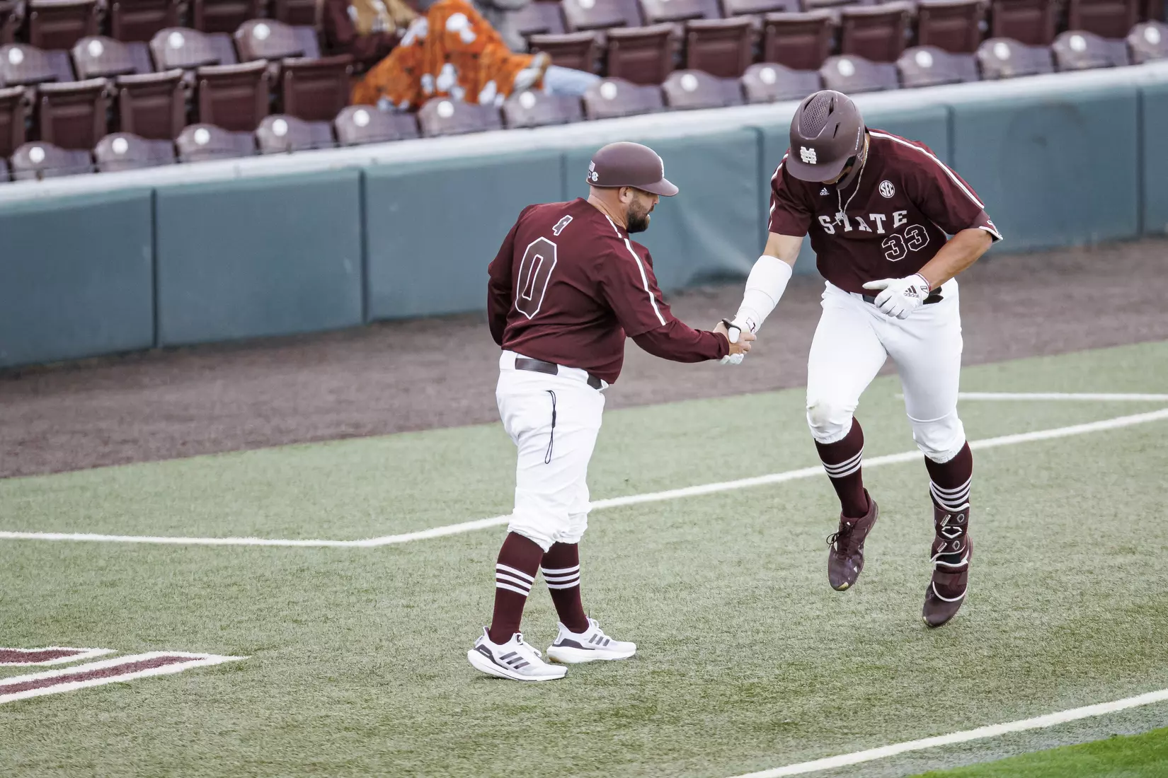 STARKVILLE, MS - March 23, 2022 - Mississippi State Baseball Camps Coordinator/Volunteer Assistant Kyle Cheesebrough and Outfielder Brad Cumbest (#33) shake hands during the game between the Southern Jaguars and the Mississippi State Bulldogs at Dudy Noble Field at Polk-Dement Stadium in Starkville, MS. Photo By Austin Perryman
