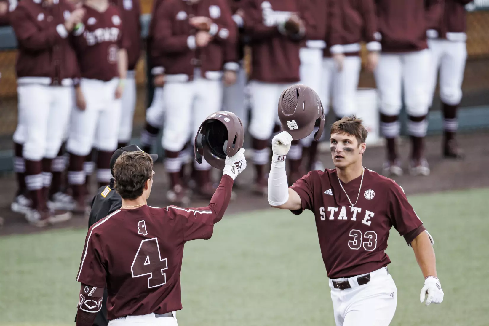 STARKVILLE, MS - March 23, 2022 - Mississippi State Infielder RJ Yeager (#4) and Outfielder Brad Cumbest (#33) tap their helmets together during the game between the Southern Jaguars and the Mississippi State Bulldogs at Dudy Noble Field at Polk-Dement Stadium in Starkville, MS. Photo By Austin Perryman