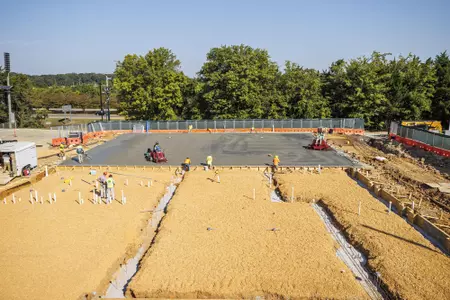 STARKVILLE, MS - September 22, 2022 - Construction workers finish the new concrete slab during construction at the MSU Softball Indoor Facility at Mississippi State University in Starkville, MS. Photo By Kevin Snyder