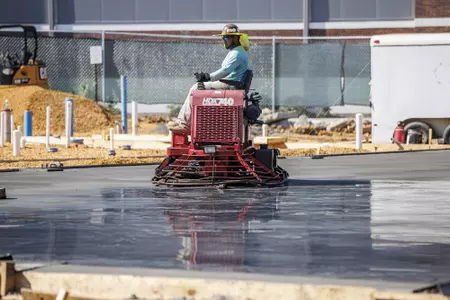 STARKVILLE, MS - September 22, 2022 - Construction workers finish the new concrete slab during construction at the MSU Softball Indoor Facility at Mississippi State University in Starkville, MS. Photo By Kevin Snyder