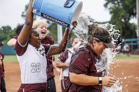 TALLAHASSEE, FL - May 22, 2022 - Mississippi State Infielder Aquana Brownlee (#20) gets Mississippi State Head Coach Samantha Ricketts with a Powerade cooler shower after the NCAA Regionals game between the Florida State Seminoles and the Mississippi State Bulldogs at JoAnne Graf Field at the Seminole Softball Complex in Tallahassee, FL. Photo By Kevin Snyder