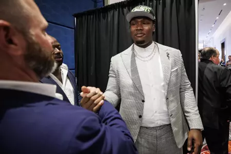 LAS VEGAS, NV - April 28, 2022 - Mississippi State Offensive Lineman Charles Cross shakes hands and hugs Offensive Line Coach & Run Game Coordinator Mason Miller after being drafted 9th overall in the 2022 NFL Draft at Caesars Forum in Las Vegas, NV. Photo By Austin Perryman