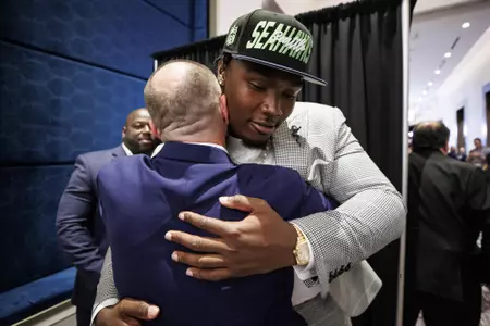 LAS VEGAS, NV - April 28, 2022 - Mississippi State Offensive Lineman Charles Cross shakes hands and hugs Offensive Line Coach & Run Game Coordinator Mason Miller after being drafted 9th overall in the 2022 NFL Draft at Caesars Forum in Las Vegas, NV. Photo By Austin Perryman