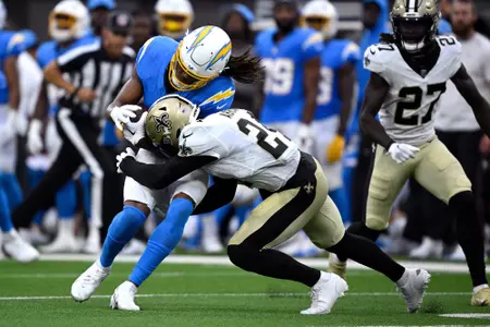 Aug 20, 2023; Inglewood, California, USA; Los Angeles Chargers wide receiver Quentin Johnston (1) is tackled by New Orleans Saints safety Johnathan Abram (24) during the first half at SoFi Stadium. Mandatory Credit: Orlando Ramirez-USA TODAY Sports