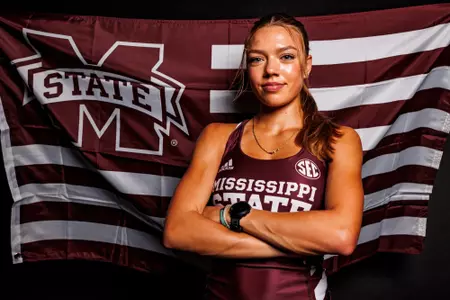 Hayley Ogle posing in front of a Mississippi State flag