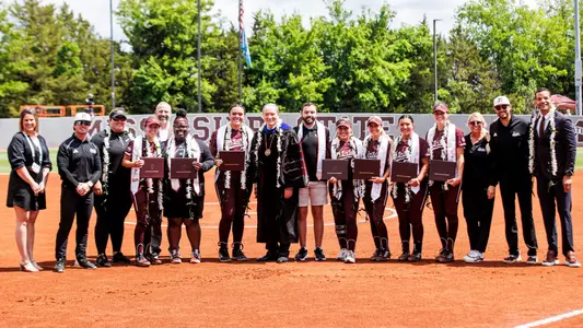 STARKVILLE, MS - May 04, 2024 - Mississippi State Infielder Kat Wallace (#2), Mississippi State Pitcher/Infielder Matalasi Faapito (#34), Mississippi State Infielder Paige Cook (#6), Mississippi State Outfielder Brylie St. Clair (#12), Mississippi State Pitcher Aspen Wesley (#28) and Mississippi State Infielder Madisyn Kennedy (#18) and Mississippi State University President Dr. Mark Keenum during the game between the Georgia Bulldogs and the Mississippi State Bulldogs at Nusz Park in Starkville, MS. Photo By Mike Mattina
