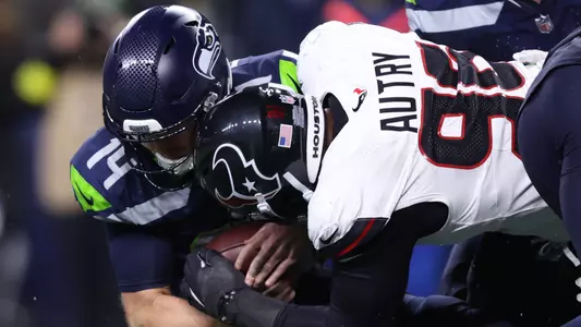 Oct 20, 2025; Seattle, Washington, USA; Houston Texans defensive end Denico Autry (96) tackles Seattle Seahawks quarterback Sam Darnold (14) during the fourth quarter at Lumen Field. Mandatory Credit: Kevin Ng-Imagn Images