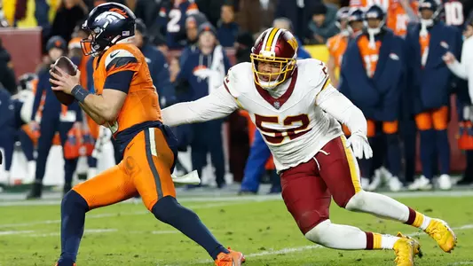 Nov 30, 2025; Landover, Maryland, USA; Denver Broncos quarterback Bo Nix (10) scrambles with the ball under pressure from Washington Commanders linebacker Preston Smith (52) in the fourth quarter of the game at Northwest Stadium. Mandatory Credit: Geoff Burke-Imagn Images
