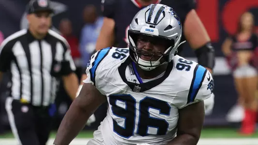 Aug 16, 2025; Houston, Texas, USA; Houston Texans quarterback Graham Mertz (18) slides as he is chased by Carolina Panthers defensive tackle Jaden Crumedy (96) in the second half at NRG Stadium. Mandatory Credit: Thomas Shea-Imagn Images