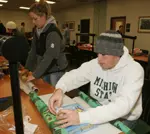 Golf team members Matt Harmon and Sara Brown wrap presents as part of the Toys & Team program.