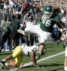 Domata Peko leaps over Michigan running back Mike Hart at the goal line to score after picking up a fumble.