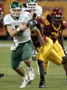 Drwe Stanton evades Minnesota linebacker Mario Reese as he scrambles for a 15-yard gain during the first quarter. (AP Photo/Ann Heisenfelt)