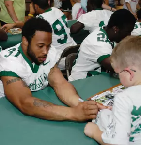 Jaren Hayes signs an autograph for a Spartan fan.