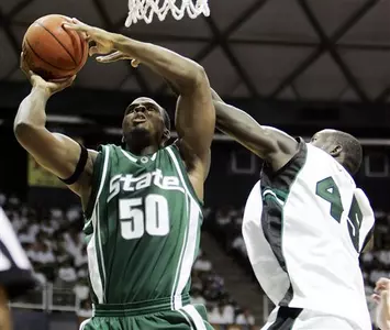 Delco Rowley is fouled by Hawaii's Ahmet Gueye as he shoots during the first half.
