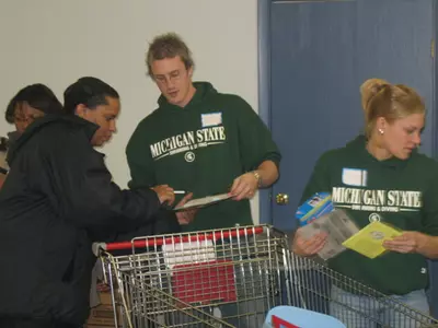 MSU swimming diving team members assist a local family at the Salvation Army Toy Shop.