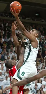 Michigan State's Alan Anderson, right, puts up a driving shot over Wisconsin's Sharif Chambliss.