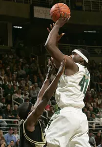 Marquise Gray puts up a basket over Johnathon Jones from Oakland University.