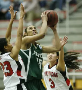 Myisha Bannister shoots between Cal State Northridge players in the first half.