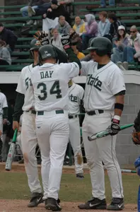 Troy Krider and Sean Walker congratulate Kyle Day at the plate after hitting his first career home run.